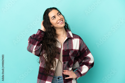 Young caucasian woman isolated on blue background thinking an idea