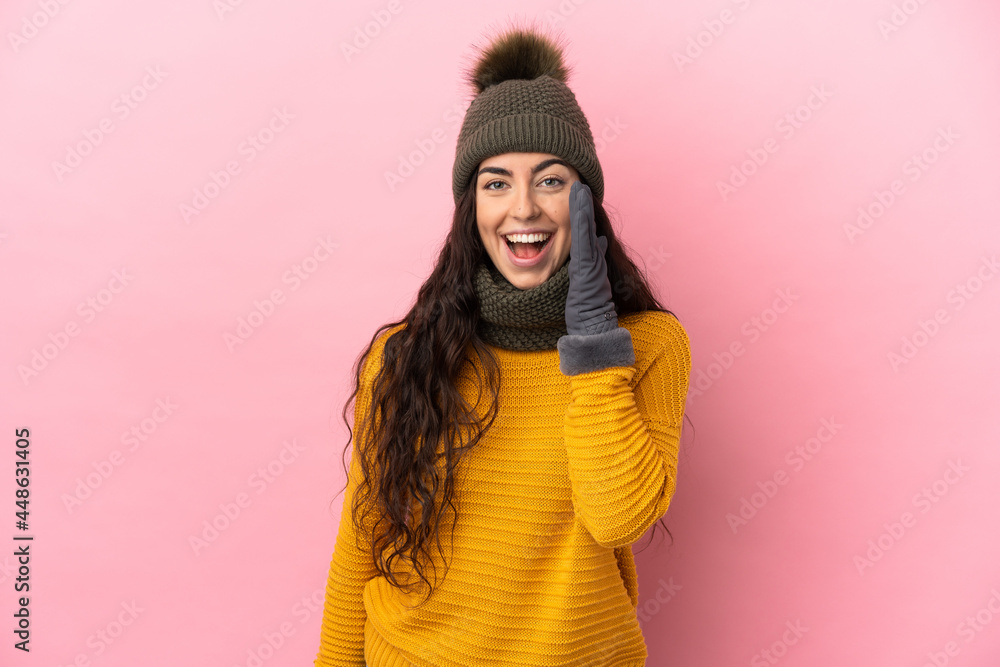 Young caucasian girl with winter hat isolated on purple background shouting with mouth wide open Young caucasian girl with winter hat isolated on purple background shouting with mouth wide open
