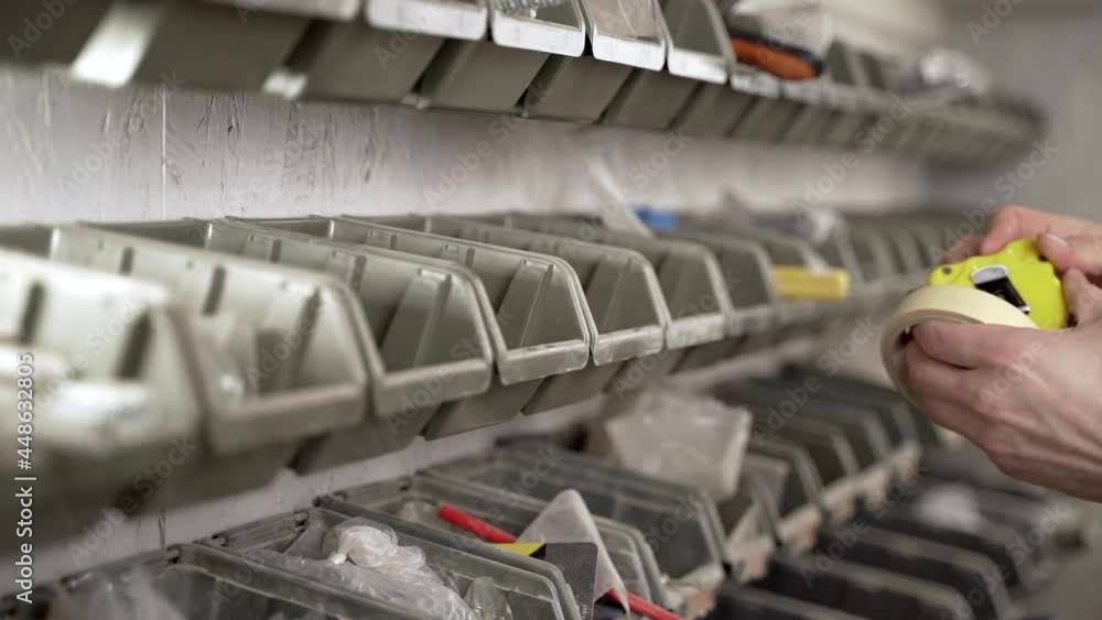 Man takes tools from the shelf in the workshop