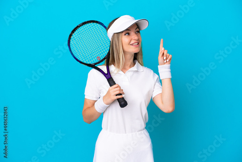 Young tennis player Romanian woman isolated on blue background pointing up a great idea © luismolinero