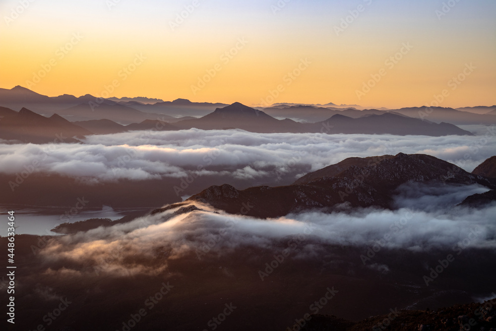 Fototapeta premium Sunrise reveals clouds rolling over Australian mountains