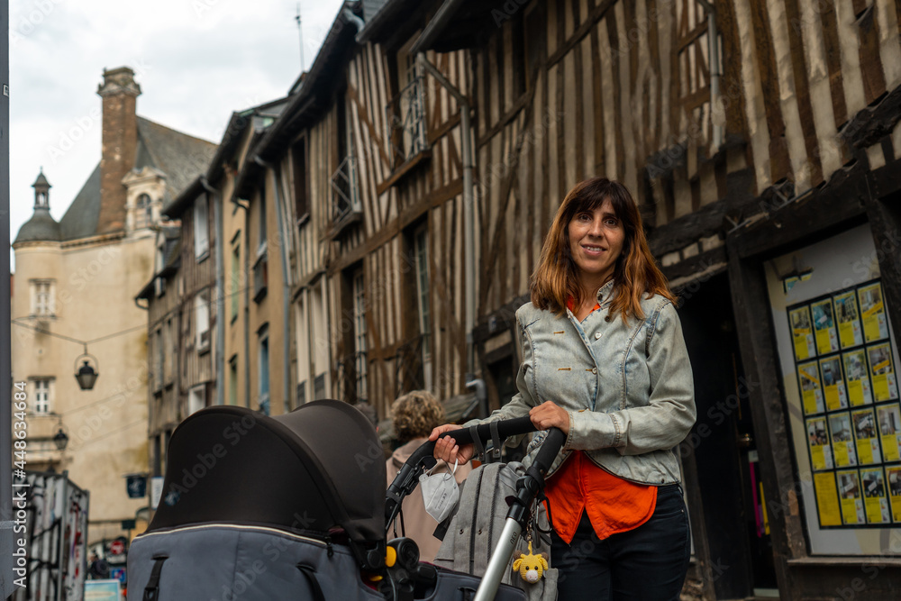 A young mother in the medieval half-timbered houses in Rennes. Capital of the province of Brittany, France