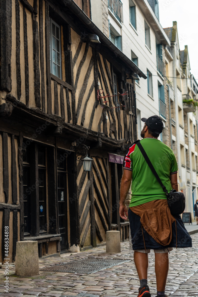 A young tourist at the medieval half-timbered houses in Rennes. Capital of the province of Brittany, France