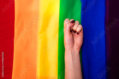 fist hand of female on the multi color flag rainbow background
