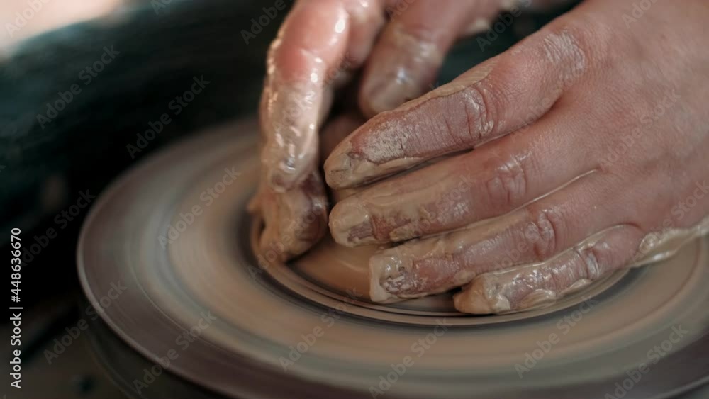 Close-up of the hand of a master potter working on a potter's wheel, forming a bowl of clay. Slow motion
Close-up of the hand of a master potter working on a potter's wheel, forming a bowl of clay. Slow motion