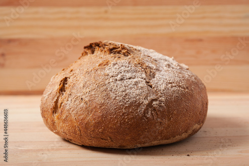 Handmade fresh wheat bread on wooden background in the morning light. horizontal close-up frame side view