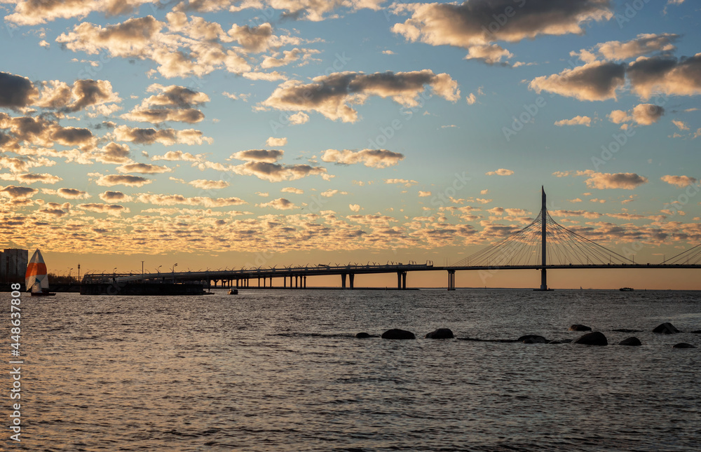 Sunset over the bay with sailboats and a view of the bridge