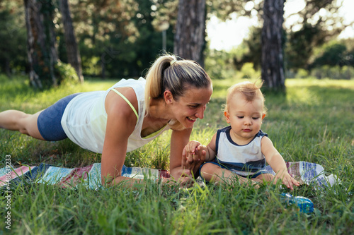 mother with her baby boy doing physical exercises outdoors