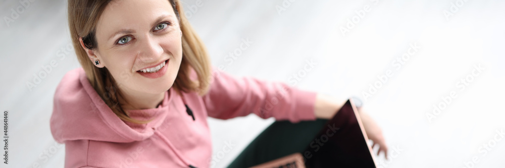 Portrait of smiling woman with notebooks sitting on floor Portrait of smiling woman with notebooks sitting on floor
