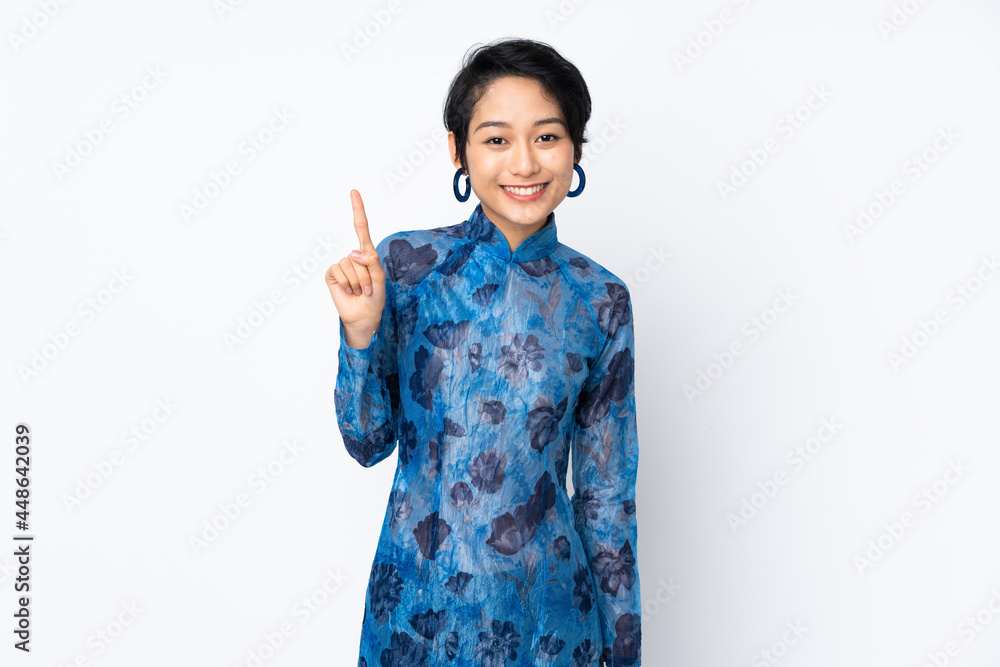 Young Vietnamese woman with short hair wearing a traditional dress over isolated white background pointing up a great idea Young Vietnamese woman with short hair wearing a traditional dress over isolated white background pointing up a great idea
