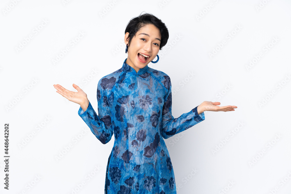 Young Vietnamese woman with short hair wearing a traditional dress over isolated white background with shocked facial expression Young Vietnamese woman with short hair wearing a traditional dress over isolated white background with shocked facial expression