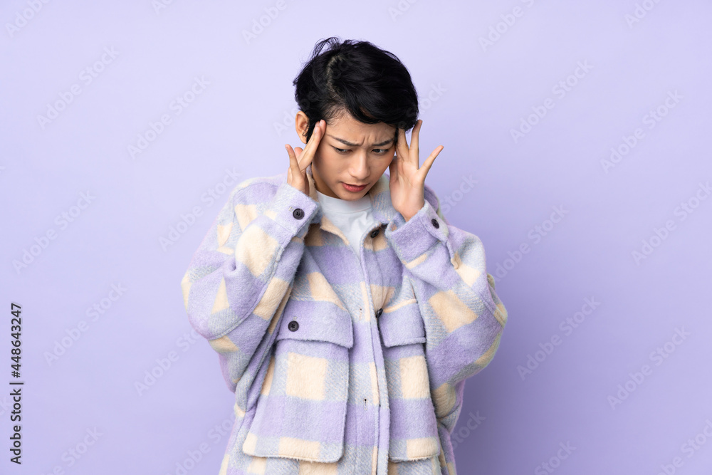 Young Vietnamese woman with short hair over isolated background with headache