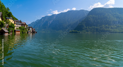 Hallstatt, Austria ; August 9, 2021 - A scenic picture postcard view of the famous village of Hallstatt reflecting in Hallstattersee lake in the Austrian Alps.