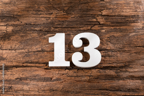 thirteen 13 - White wooden number on rustic background photo