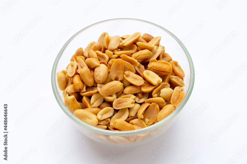 Peeled peanuts in glass bowl on white background. Peeled peanuts in glass bowl on white background.