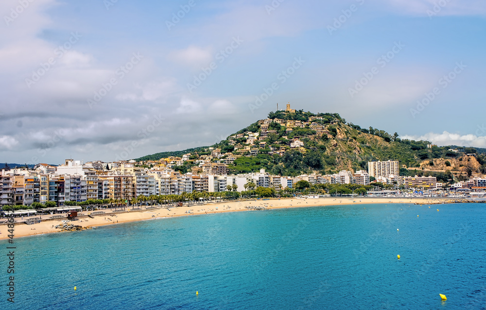 Tourists enjoy at the beach in Blanes in Costa Brava in a beautiful summer day, Spain