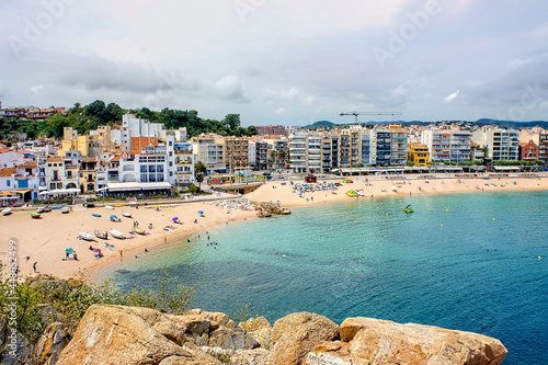Tourists enjoy at the beach in Blanes in Costa Brava in a beautiful summer day, Spain