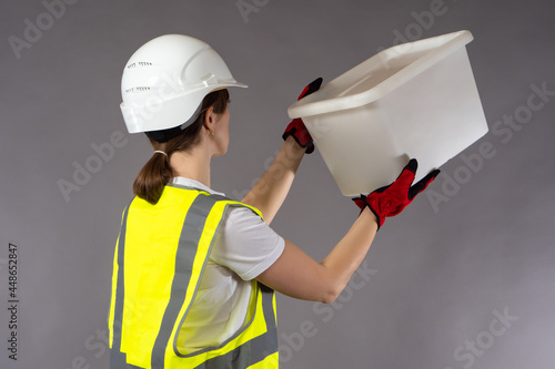 Woman builder on gray backg...