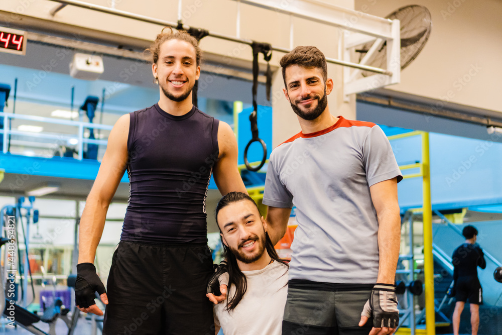 a brazilian and two latin and hispanic men smiling in sportswear in a gym.