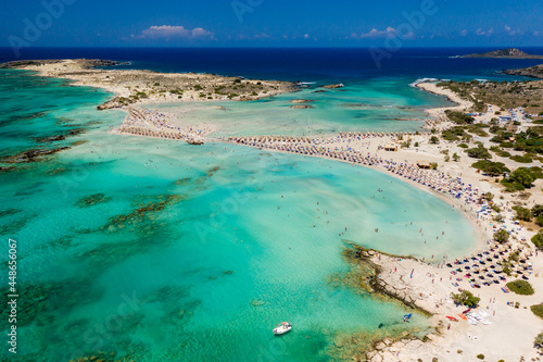 Fototapeta Naklejka Na Ścianę i Meble -  Aerial view of a beautiful but busy sandy beach and shallow lagoons surrounded by clear, blue ocean (Elafonissi, Crete)