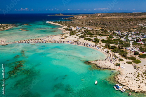 Aerial view of shallow sandy lagoons and a beach surrounded by deeper dark blue sea (Elafonissi Beach) © whitcomberd