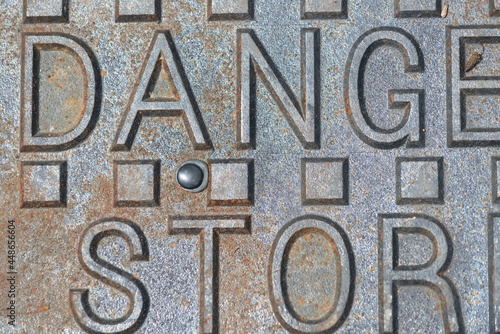 partial inscription on a manhole cover: danger storm