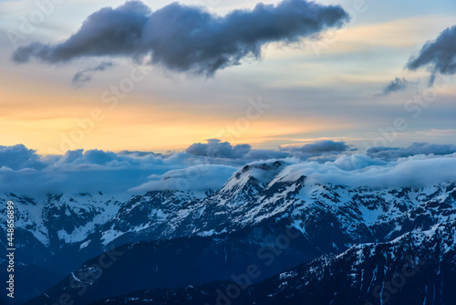 Aerial View from Airplane of Canadian Mountain Landscape in Spring time. Colorful Sunset Sky. North of Vancouver, British Columbia, Canada. Authentic Image