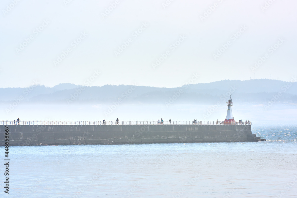 Ogden Point Breakwater Victoria. A misty day as people visit the Ogden Point breakwater and lighthouse in Victoria.

