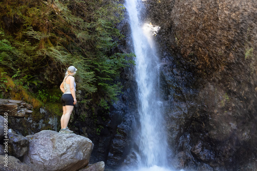 Adult Woman hiker at Norvan Falls and river stream in the natural canyon during the summer time. Canadian Nature Background. Lynn Valley, North Vancouver, BC, Canada.