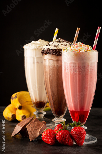 Three glasses of milkshake with assorted flavors. Chocolate, vanilla and strawberry milkshake. photo