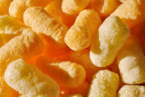 Closeup of puffcorn under sunlight. Sweet snack corn puffs. Macro of puffed corn
