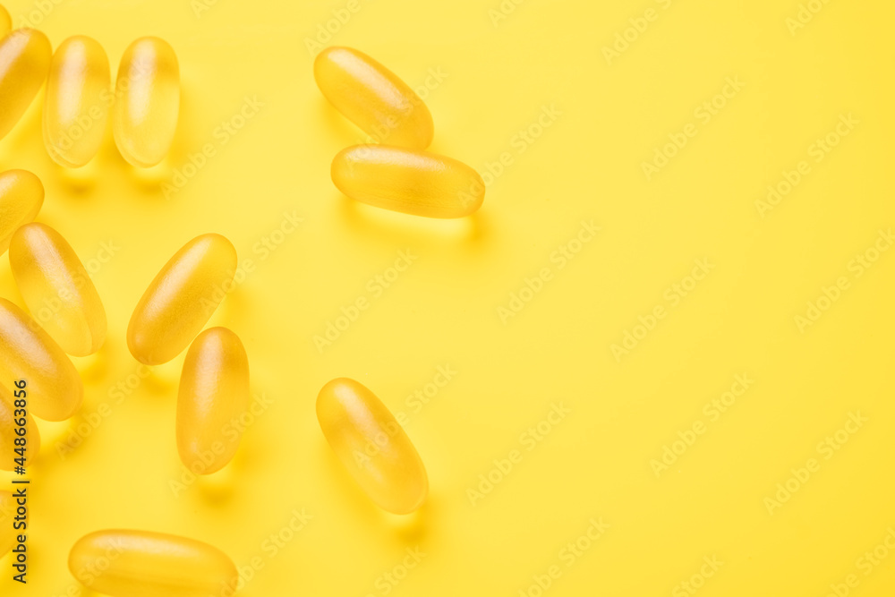 Close up Omega 3 capsules on yellow background. Fish oil softgels. Copy space for your text