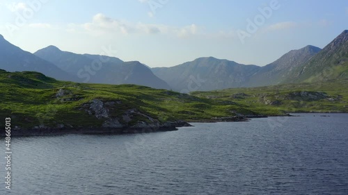 Derryclare Lough, Connemara, County Galway, July 2021. Drone slowly pushes north low along the lakeshore, while gradually pushing towards the Twelve Bens mountains. photo