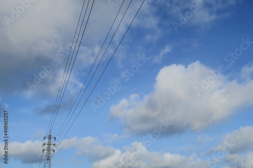 Electrical power lines with blue sky and white cloud in the background in Kasukabe, Saitama, Japan. August 3, 2021.