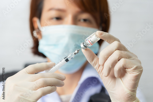 Asian medical worker  nurse in mask  hold syringe with vaccine. Covid-19  coronavirus disease  healthcare workers concept.