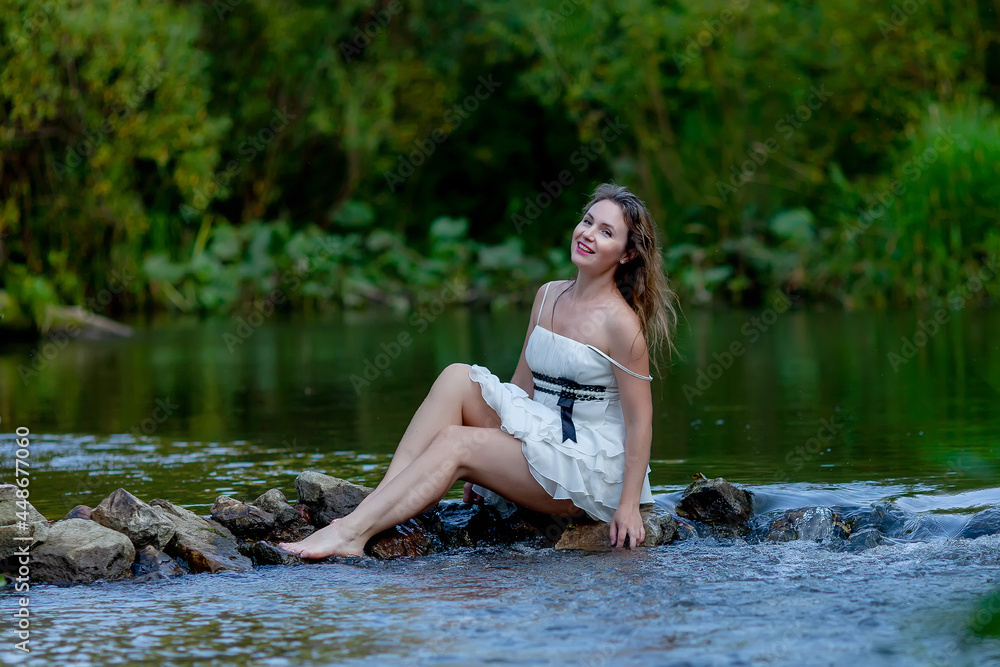 woman in white dress splashes in the river woman in white dress splashes in the river