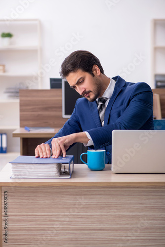 Young male employee and too much work in the office