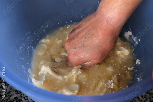 Preparing dough for baking, selective focus. Woman's hand kneading pastry dough. Preparation of homemadeTurkish flat bread, pide or pizza base in the kitchen. It is called "Hamur Yogurma" in Turkish.
