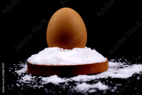 An egg above the salt or salty egg in black background in HD size