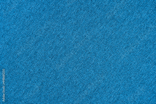 Blue texture of fabric from a textile material for an abstract background for an empty surface and for wall-paper.