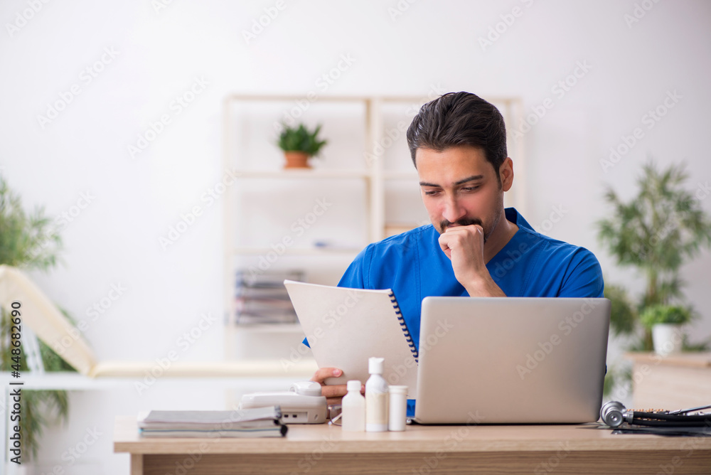 Young male doctor working in the clinic Young male doctor working in the clinic