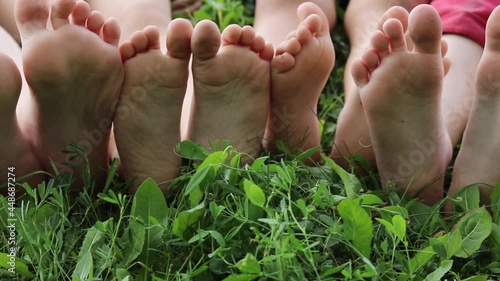 kids bare soles on grass, hardening foot concept photo