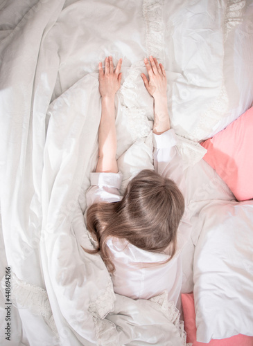 Woman starting her day stretching in bed