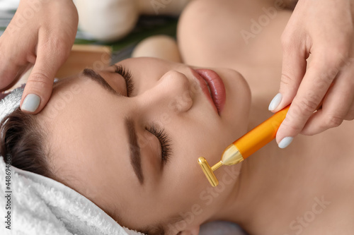 Young woman receiving face massage in beauty salon