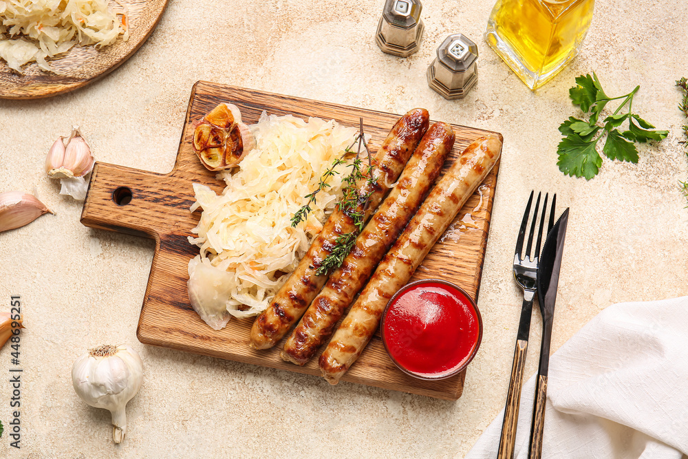 Board with tasty sauerkraut, grilled sausages and sauce on grunge background Board with tasty sauerkraut, grilled sausages and sauce on grunge background