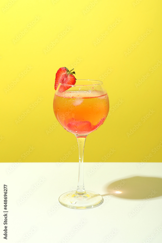 Glass of fresh summer cocktail against yellow background