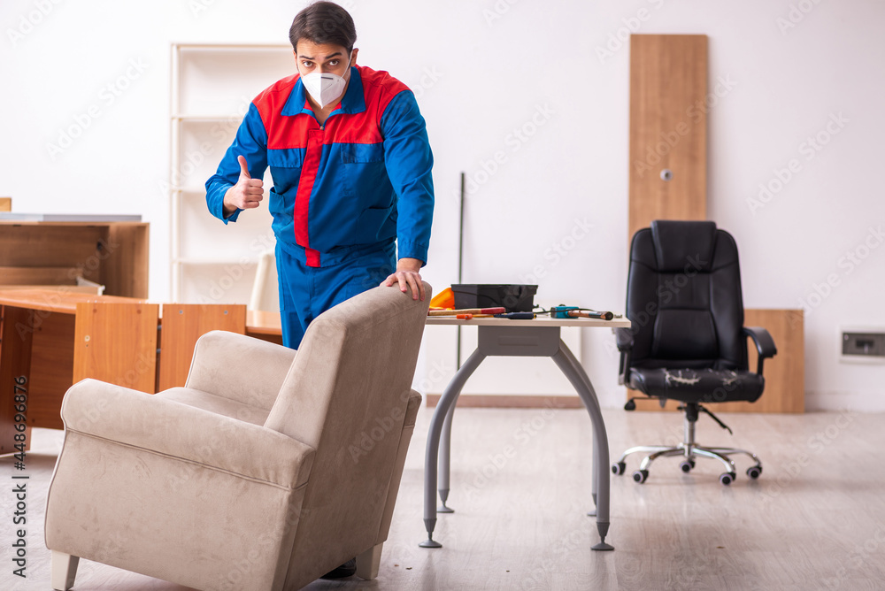 Young male carpenter working in the office during pandemic
