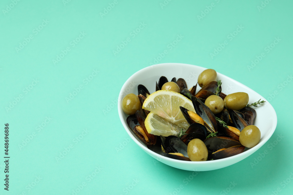 Bowl of mussels with spices on mint background Bowl of mussels with spices on mint background