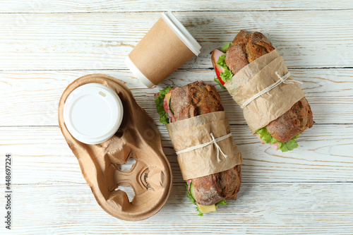 Ciabatta sandwiches and coffee cups on white wooden table