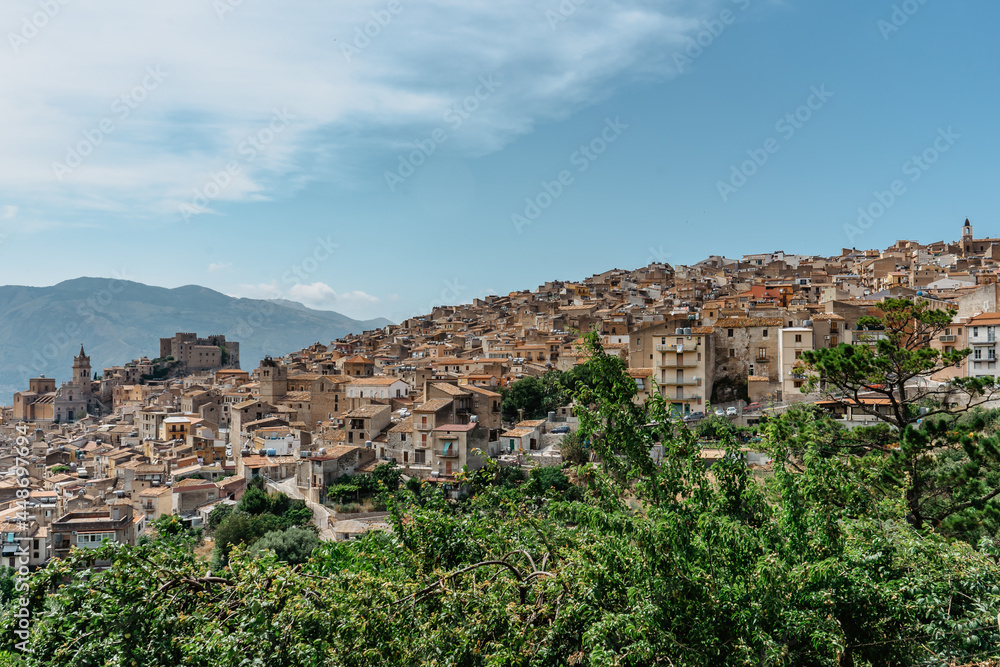 Caccamo, Sicily, Italy. View of popular hilltop medieval town with impressive Norman castle and surrounding countryside.Italian landscape.Picturesque village on hill with mountains in background.